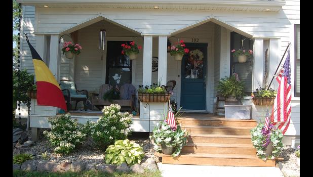 Adam and Chassidy DeRoode annually hang up a Belgian and an American flag on the front porch of their home during Belgian-American Days. Mascot photo by Scott Thoma
