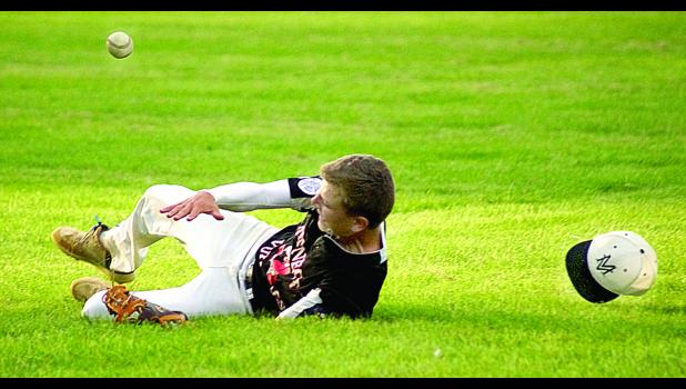 Photo for the Mascot by Sue Jacobson. Minneota Junior Vulture shortstop Ben Skorczewski ran into left field in an attempt to catch a popup by BOLD in Tuesday night’s game. He nearly made the catch, but it just got past him and bounded away for a base hit. Minneota lost in extra innings, 6-5. Photo for the Mascot by Sue Jacobson.