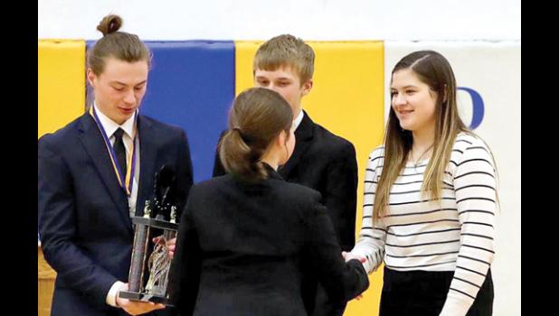 Photo by Reba Lipinski. Enjoying the Minneota third place trophy from Adrian was Brenden Kimpe. Beside him was Jacob Haen as Katie Walerius was congratulated as well.