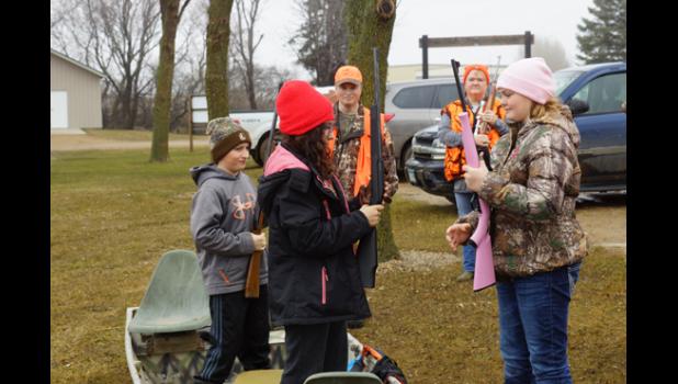 Photo for the Mascot by Sue Jacobson. Brock Kremin waited as Jasmine Peterson and Ella Moorse practice the safe handling of their weapons.