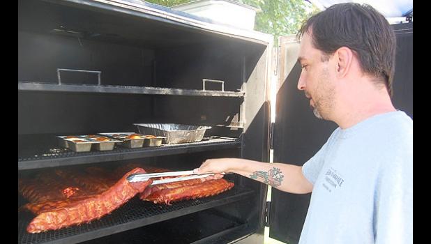 Staff photo by Scott Thoma. People's Choice winner Dallas Reese of Lennox, SD checks his ribs during the competition.