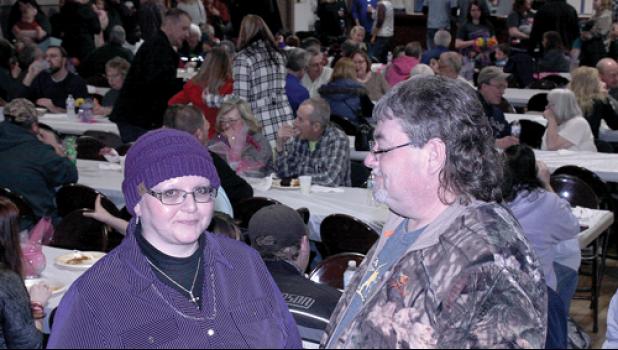 Staff Photo by Byron Higgin. Fiancé Lee Kilpatrick gave Chris Hansen an admiring look with the jam-packed crowd behind them. Kilpatrick has been a large part of the support group for Hansen during her fight.