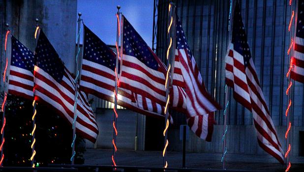Staff Photo by Byron Higgin. Flags flew in the wind as the "Light the Lights" lite up the night at Veteran's Park.