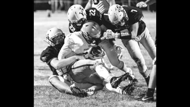 Wyatt Moore, lower left, of Minneota brings down a YME ball carrier while getting help from Sawyer Bradley (22) and Sam Myhre (7).