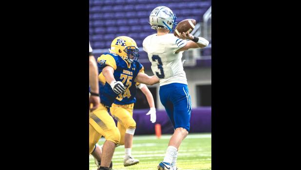 Mascot photo by Brian Jeremiason Kayden Neyens (75) of Minneota bears down on BBE quarterback Luke Illies in first-half action Saturday .