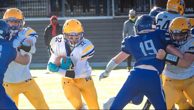 Mascot photo by Brian Jeremiason Zack Fier of Minneota runs through a hole in the line en route to a large gain on Friday against Lakeview in the Section 5A championship.