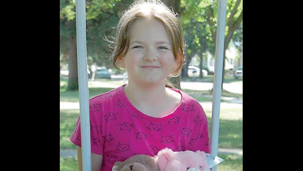 Staff photo by Scott Thoma. Hannah sits on her swing with two of the teddy bears she recently was given as a gift. She will be donating them next June to kids in Ecuador.