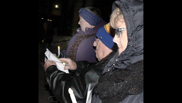 Staff Photo by Byron Higgin. Alan and Sandy Josephson and others gathered to display the lighted candles and sing Christmas songs, led by Roberta and Scott Josephson sang Christmas songs for the public.