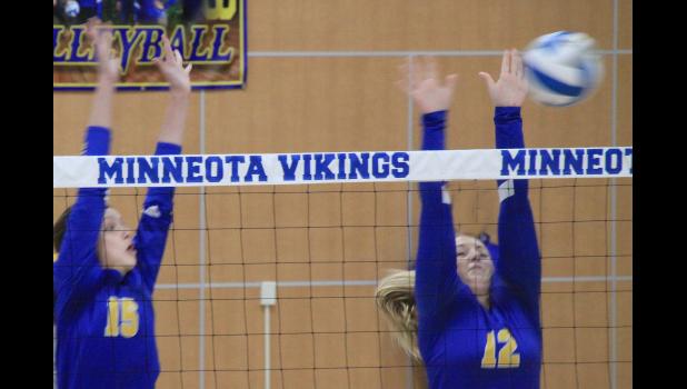 Staff Photo by Byron Higgin Minneota's Sydney Larson went high to block a Windom hit. Also up to help was Abby Frie.