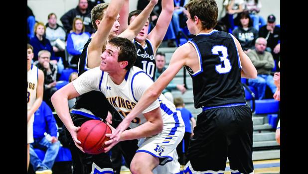 Photo for the Mascot by Brian Jeremiason. Logan Sussner splits a triple team on his way to the basket. Sussner had 31 points and 15 rebounds.
