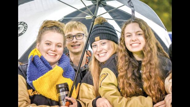 Photo for the Mascot by Brian Jeremiason. Mariah Muhl, Jacob Haen, Reese Gillund and Merissa Traen sought shelter under an umbrella at the Minneota vs. Springfield football game on Friday in Minneota.