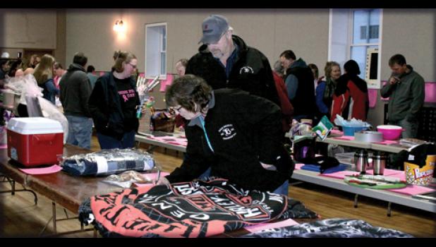 Staff Photo by Byron Higgin. The Silent Auction included a variety of gifts and everyone had a chance to bid on them. Here Randy and DJ Prellwitz looked over the merchandise and signed up.