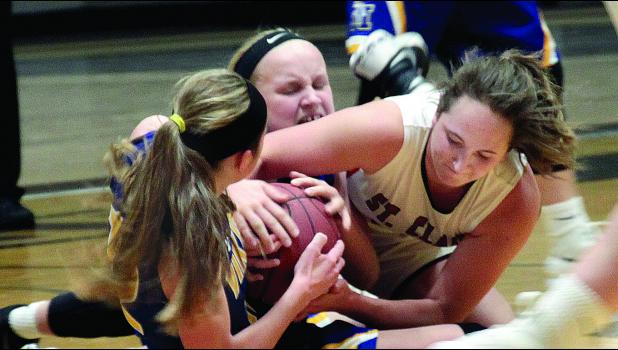 Staff Photo by Byron Higgin. A scramble on the floor found Abby Rost (back) of Minneota, Natalee Rolbiecki (left) and St. Clair's Olivia Drummer fighting for the ball.