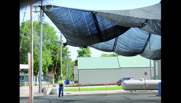 Staff Photo by Byron Higgin A man stood under the tarp as he awaiting to help deliver outdoor toilets to Boxelder Bug Days.