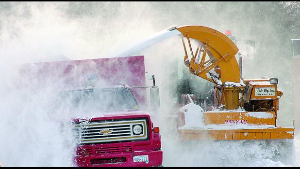Staff Photo by Byron Higgin. Winds were still blowing as the crew tried to clean up the streets.