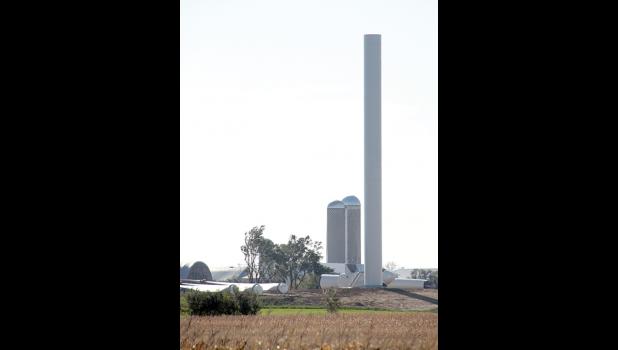 Staff Photo by Byron Higgin. A turbine towered over the top of the silos at an area farm.