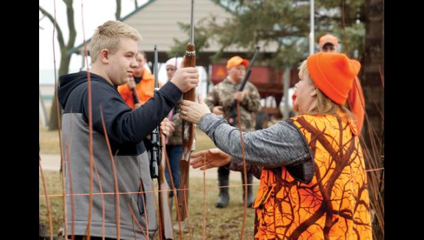 Photo for the Mascot by Sue Jacobson. Jennifer Neyes (left), taking a gun over a fake fence from Ty Baune.