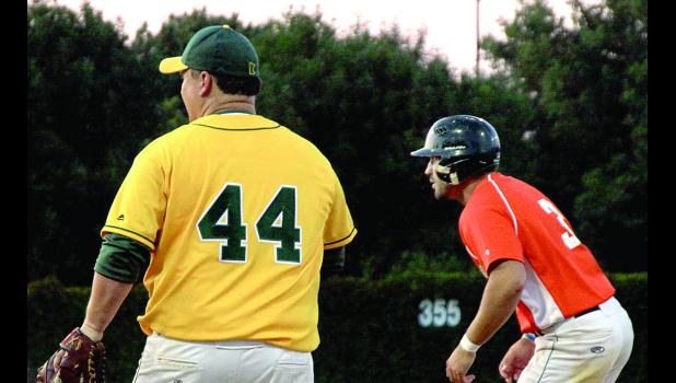 Staff Photo by Byron Higgin Tyson Sonnenburg (right) studied the Marshall pitcher. The first baseman is Marshall A's Manager Buddah Greenwood, a former Mudhen.