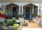 Adam and Chassidy DeRoode annually hang up a Belgian and an American flag on the front porch of their home during Belgian-American Days. Mascot photo by Scott Thoma
