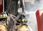 Minneota firemen look at the truck's engine after the fire was doused.