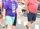 Cancer survivors and area residents David Moriarty, Ruth Bot, Nancy Crowley, Kathy Wohnoutka and Cletus Lanners lead a large group in walking around the luminaria path during the Lyon County Relay for Life last Thursday in the Schwan's parking lot in Marshall. 