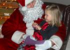Claire Williams, wearing her bright red Christmas dress, told Santa Claus what she wanted for Christmas at the Minneota Public Library recently. 