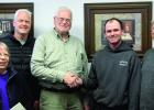 Turning the building over to the city was Owen Schott (third from left). He shook hands with Brad Minnehan of ADOM with City Administrator Shirley Teigland (left) on hand with ADOM members Kevin Anundson and Bill Ufkin (right) also on hand. 