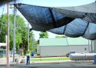 A man stood under the tarp as he awaiting to help deliver outdoor toilets to Boxelder Bug Days.